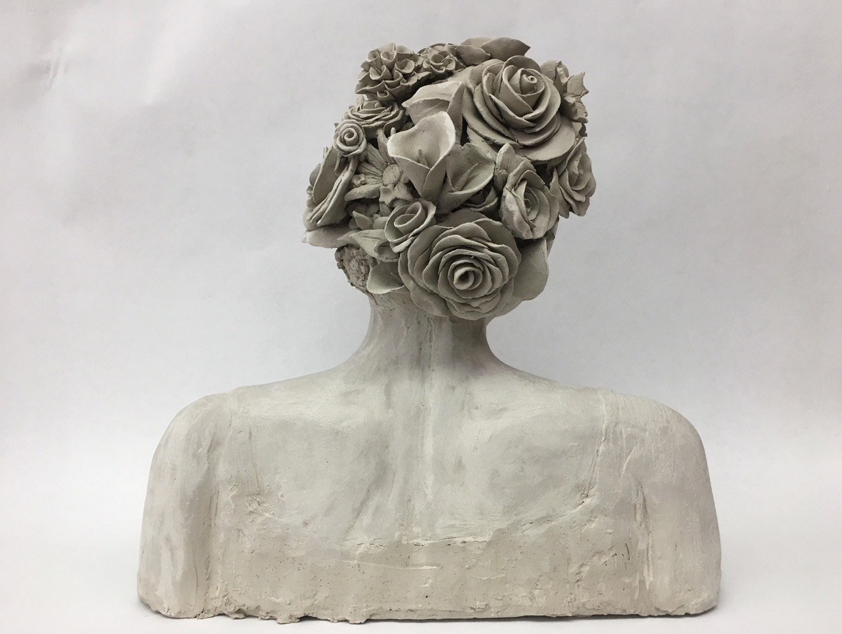 Clay bust with a sculpted flower crown by Faye, back view with roses